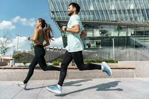 Runners couple training full-length running.  Using smart watches for fitness, sportswear and running shoes. Friends are fitness people who train together. photo