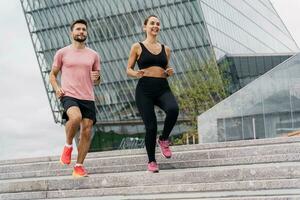 personas en ropa de deporte juntos, físico educación y Deportes. atlético hombre y mujer tren en aptitud y correr. utilizando inteligente relojes y un aptitud aplicación equipo ejercicios de un joven Pareja. foto