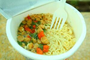 Eat Instant Noodles with Plastic Fork, complete with vegetables photo