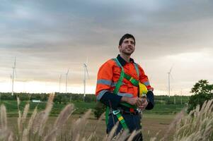 retrato de inteligente ingeniero con protector casco a eléctrico turbinas campo foto