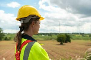 Portrait of smart engineer with protective helmet at electrical turbines field photo