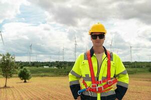 retrato de inteligente ingeniero con protector casco a eléctrico turbinas campo foto