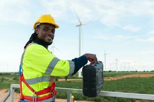 Portrait of smart engineer with protective helmet at electrical turbines field photo