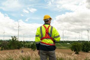 retrato de inteligente ingeniero con protector casco a eléctrico turbinas campo foto