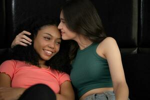 retrato de dos Adolescente muchachas sentado en cama en dormitorio y besos su amigo en el frente foto