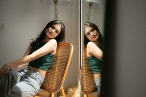 Beautiful asian woman sitting on chair and looking out the window photo