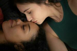 Young woman kissing her friend on the forehead photo