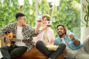 Multiethnic group of friends having fun playing guitar and singing together at home photo