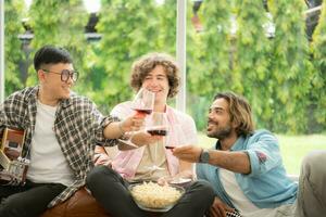 Multiethnic group of friends having fun playing guitar and singing together at home photo