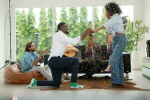 A group of multiethnic friends having fun at a party and witness their friend's marriage proposal. photo