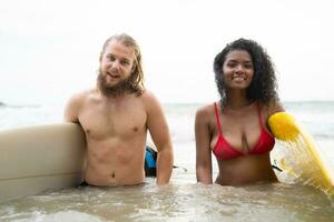 Young couple of surfers with surfboard on the beach photo