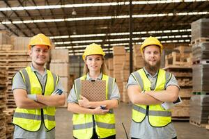 Portrait of happy team of warehouse workers standing with clipboard in wooden warehouse photo