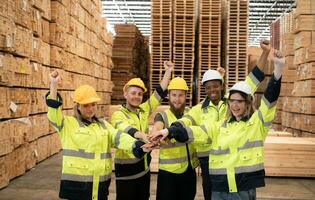 Portrait of happy workers giving high five at warehouse. This is a a large timber factory. Industrial and industrial workers concept photo