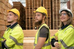 grupo de trabajadores en un grande madera fábrica, tener divertido por levantamiento tu brazos después completando el días trabajar. foto