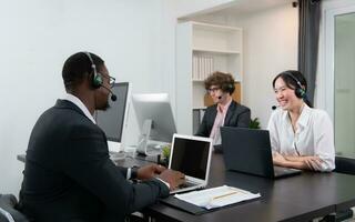 Group of business people wearing headset working actively in office. Call center, telemarketing, customer support agent provide service on telephone video conference call. photo