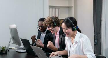 grupo de negocio personas vistiendo auriculares trabajando activamente en oficina. llamada centro, telemercadeo, cliente apoyo agente proporcionar Servicio en teléfono vídeo conferencia llamar. foto