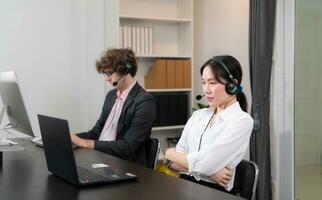 Group of business people wearing headset working actively in office. Call center, telemarketing, customer support agent provide service on telephone video conference call. photo