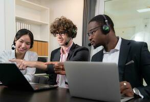 Group of business people wearing headset working actively in office. Call center, telemarketing, customer support agent provide service on telephone video conference call. photo