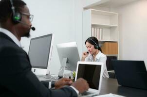 Group of business people wearing headset working actively in office. Call center, telemarketing, customer support agent provide service on telephone video conference call. photo