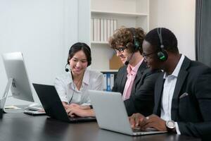 Group of business people wearing headset working actively in office. Call center, telemarketing, customer support agent provide service on telephone video conference call. photo