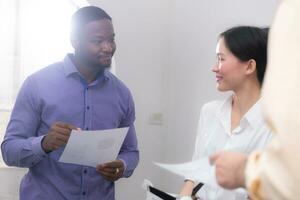 Business people discussing the charts of machine showing the results of their successful teamwork photo