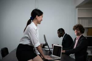 Group of business people wearing headset working actively in office. Call center, telemarketing, customer support agent provide service on telephone video conference call. photo