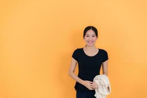 Portrait of a happy young asian woman isolated on yellow background photo