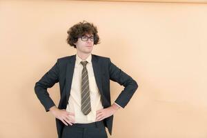 Portrait of a handsome young man with curly hair on a beige background photo