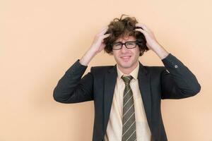 Portrait of a handsome young man with curly hair on a beige background photo