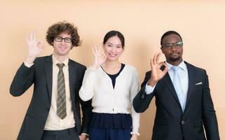 Portrait of group multi ethnic business people together showing ok hand sign with fingers photo