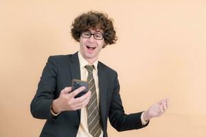 Portrait of a handsome young man with curly hair on a beige background photo