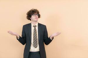 Portrait of a handsome young man with curly hair on a beige background photo