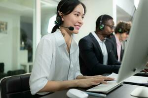 Group of business people wearing headset working actively in office. Call center, telemarketing, customer support agent provide service on telephone video conference call. photo