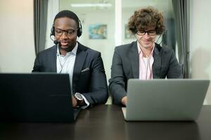 Group of business people wearing headset working actively in office. Call center, telemarketing, customer support agent provide service on telephone video conference call. photo