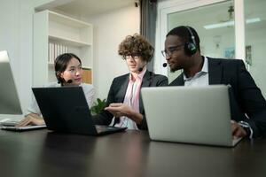 Group of business people wearing headset working actively in office. Call center, telemarketing, customer support agent provide service on telephone video conference call. photo