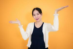 Portrait of a happy young asian woman isolated on yellow background photo