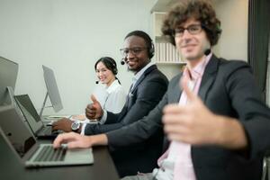 Group of business people wearing headset working actively in office. Call center, telemarketing, customer support agent provide service on telephone video conference call. photo