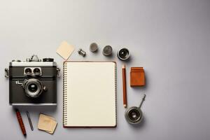 parte superior ver de Clásico cámara cuaderno y papelería en gris antecedentes ai generado foto