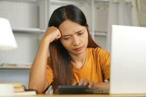 Asian woman working from home Tired of paperwork that is not completed on time photo