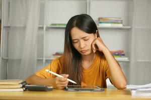 Asian woman working from home Tired of paperwork that is not completed on time photo