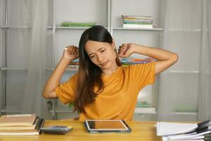 Asian woman working from home having pain from sitting for a long time photo