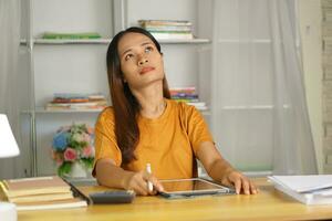 Asian woman working from home Tired of paperwork that is not completed on time photo