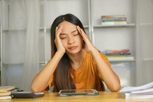 Asian woman working from home Tired of paperwork that is not completed on time photo