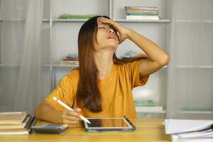 Asian woman working from home Tired of paperwork that is not completed on time photo