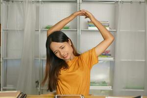 Asian woman working from home having pain from sitting for a long time photo