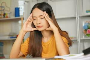 Asian woman working from home Tired of paperwork that is not completed on time photo