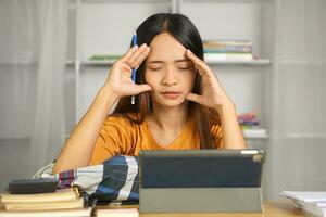 Asian woman working from home Tired of paperwork that is not completed on time photo