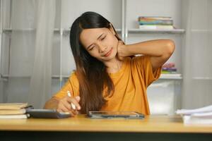 Asian woman working from home having pain from sitting for a long time photo