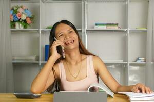 woman working at home Use your phone and computer to communicate with your teammates. photo