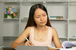 Asian woman working from home Tired of paperwork that is not completed on time photo